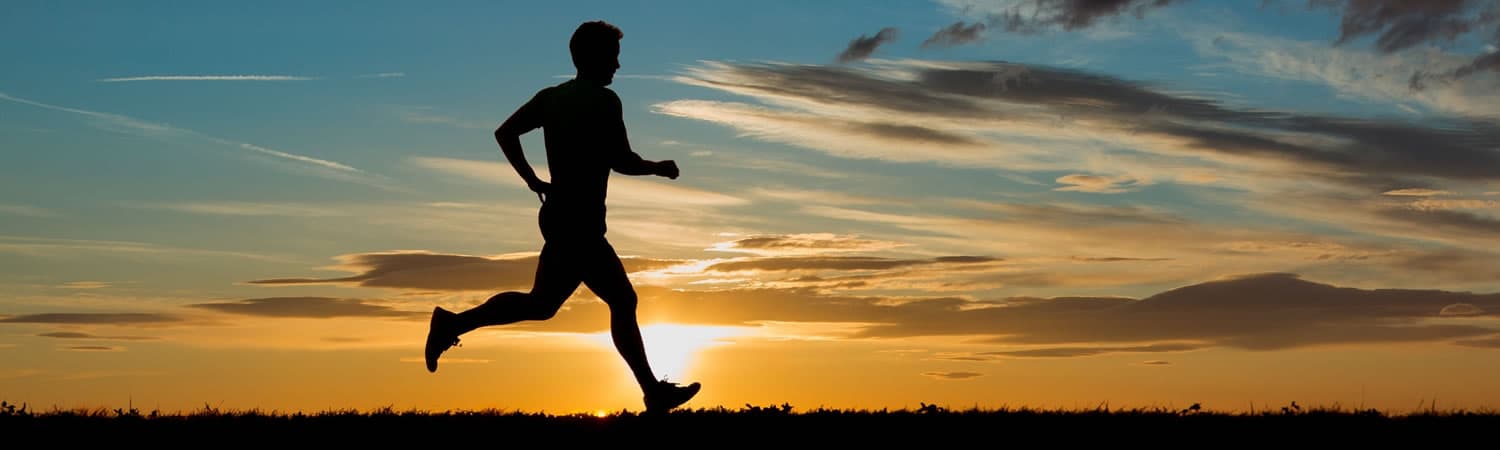A healthy man running in the sunset